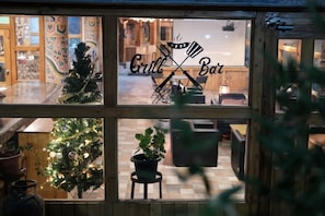 A restaurant with a Christmas tree and a sign that reads 'Grill & Bar'.