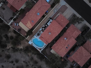 Ein Luftbild eines Wohngebiets mit mehreren Häusern, einem Swimmingpool und einem klaren Himmel.