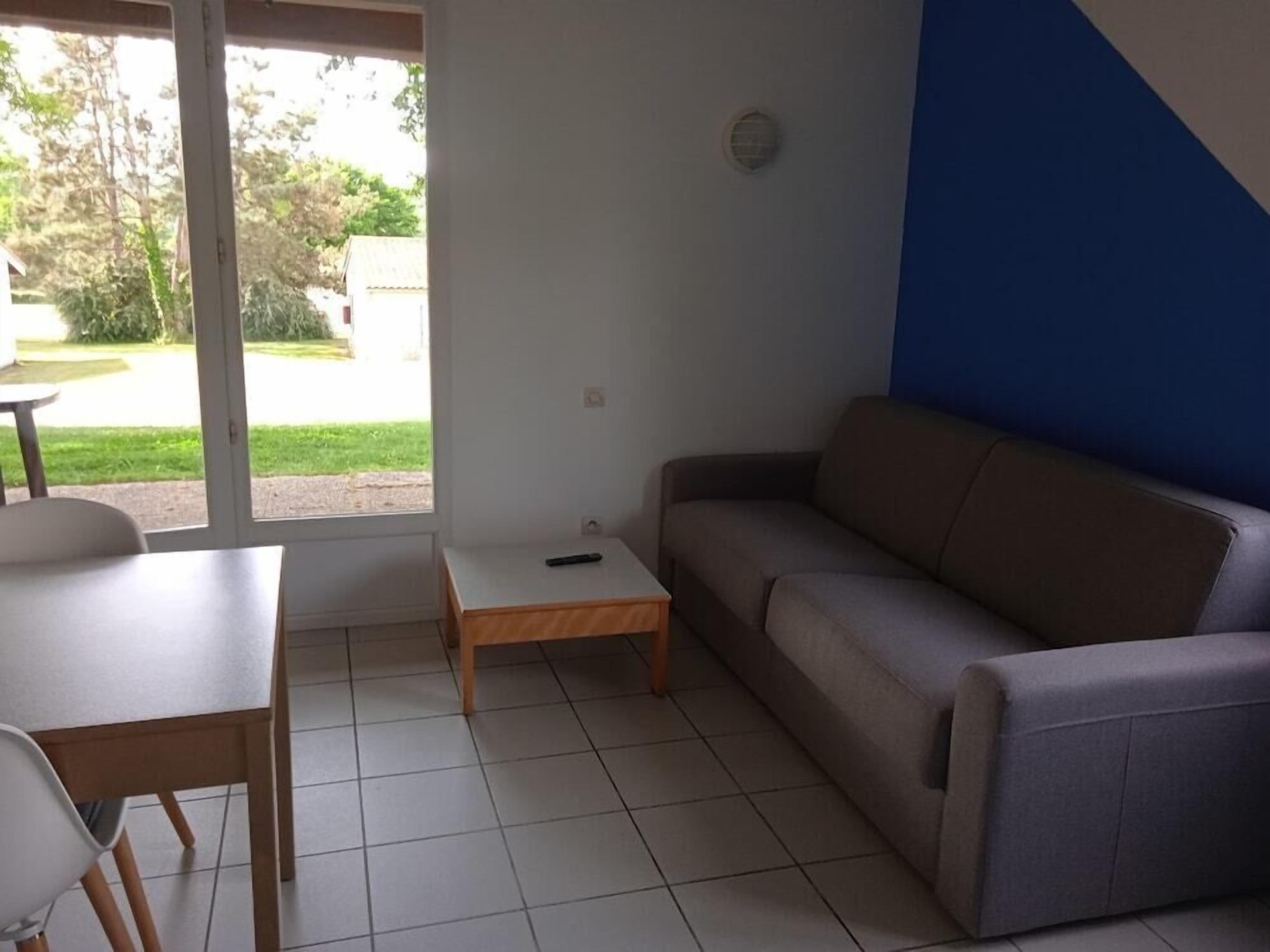Une pièce avec un canapé, une petite table et une chaise.
