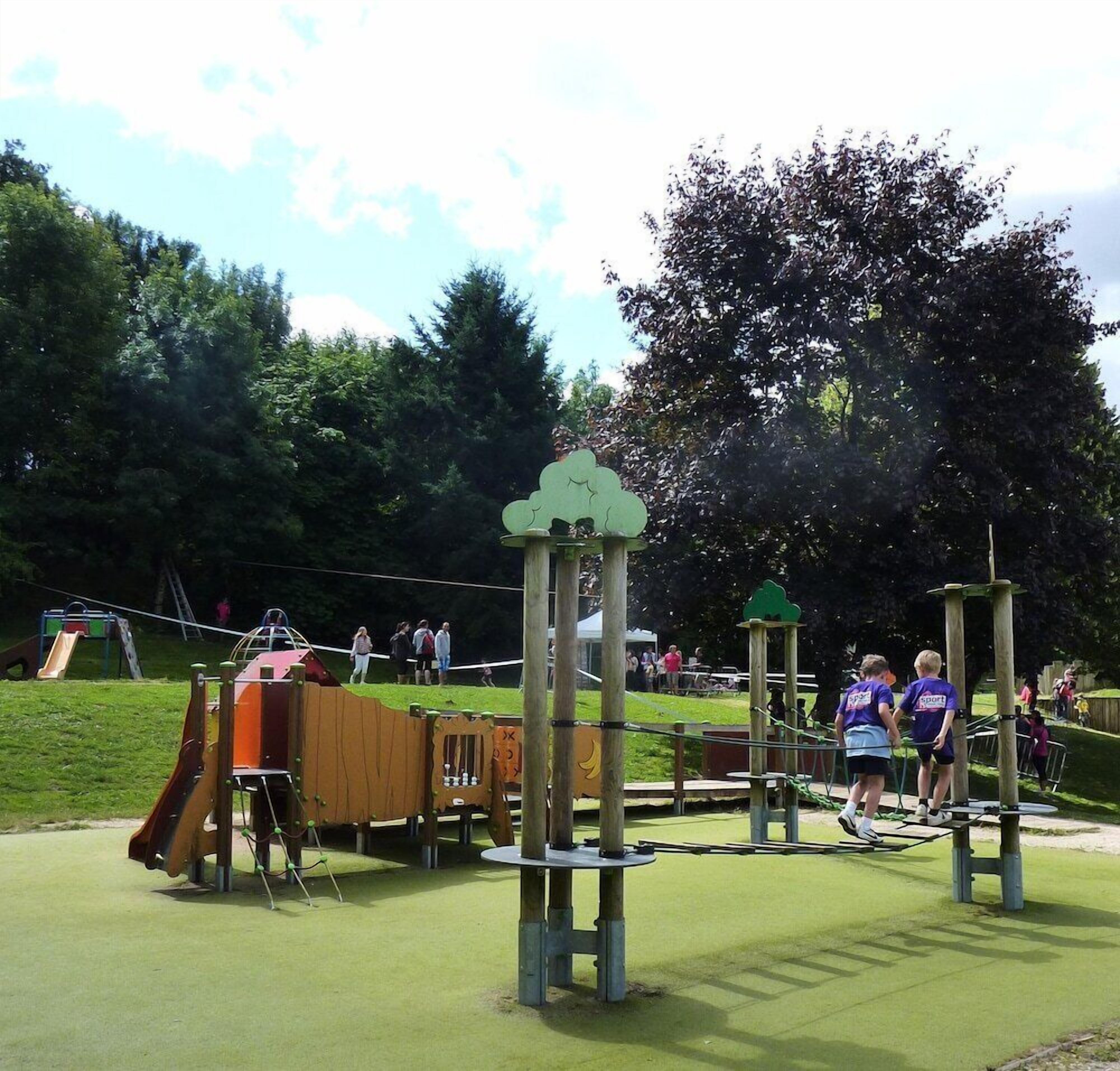 A playground with various play structures, including a slide and climbing frames.