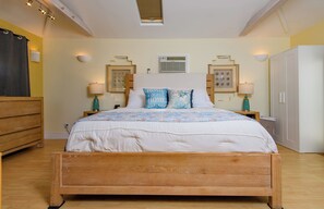 A bedroom with a wooden bed, two bedside tables with lamps, a wardrobe, and a ceiling light fixture. - Pacific Beach Family Escape/Hot tub+Lg Play Yard (San Diego)