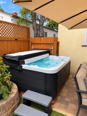 A hot tub with a wooden deck and a patio chair. - Pacific Beach Family Escape/Hot tub+Lg Play Yard (San Diego)