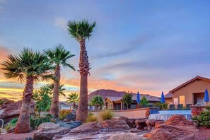 Ein Resort mit Palmen, einem Pool und einem Berg im Hintergrund.