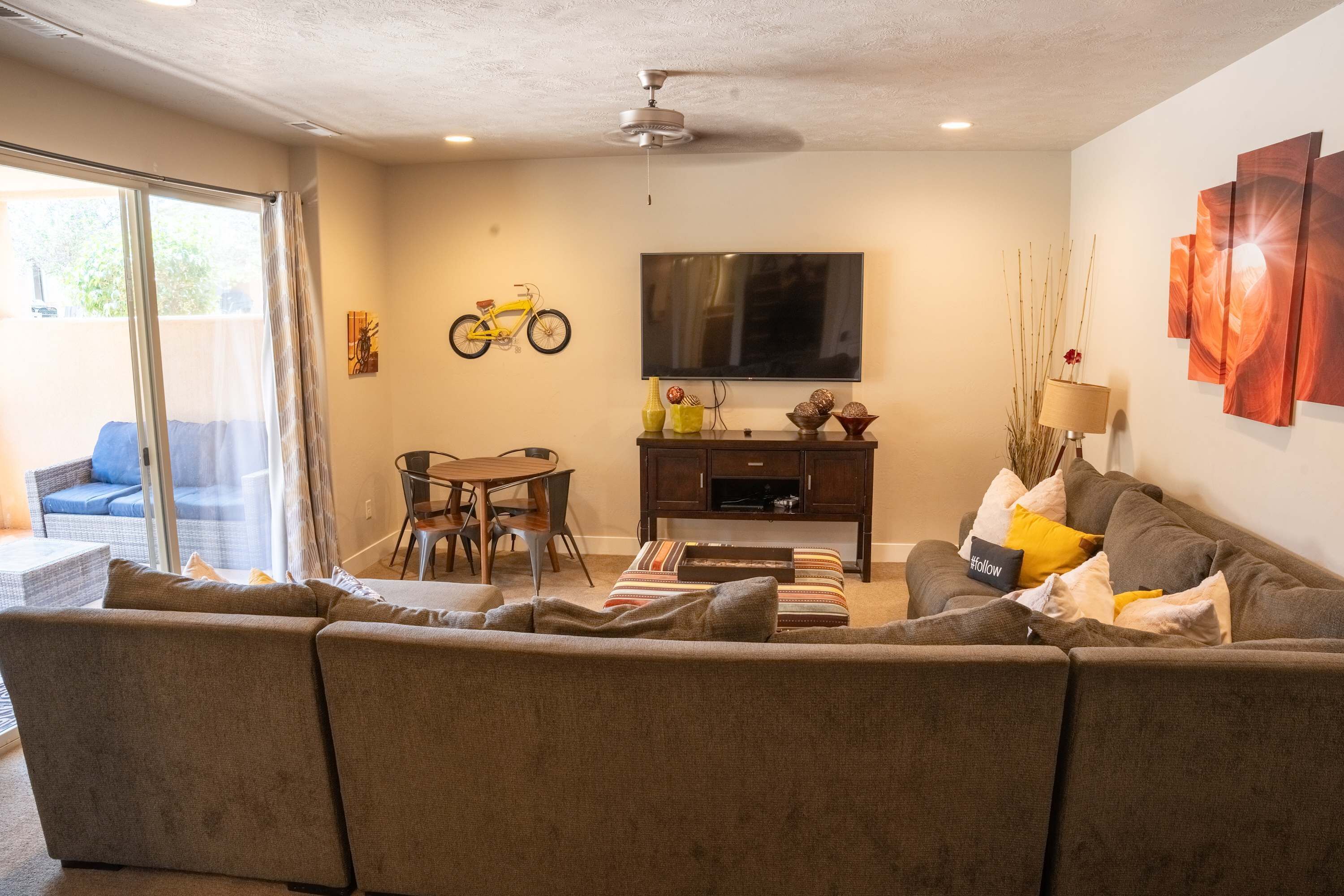 Een woonkamer met een bank, een televisie en een eettafel.