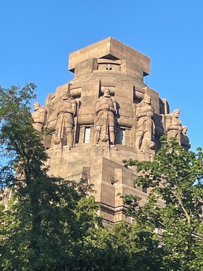 Ein großes Steins Denkmal mit mehreren Statuen, umgeben von Bäumen.