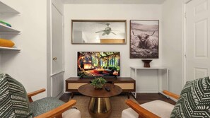 Ein Wohnzimmer mit Fernseher, Deckenventilator, Kamin und einer Couch.