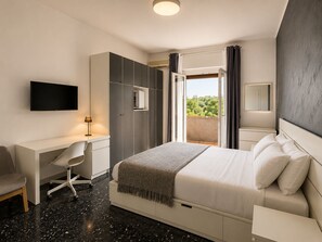 Un dormitorio moderno con cama, escritorio, silla y televisor.