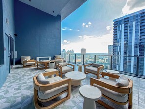 Ein Balkon mit Sitzgelegenheit, einem großen Fenster und Blick auf die Stadt.