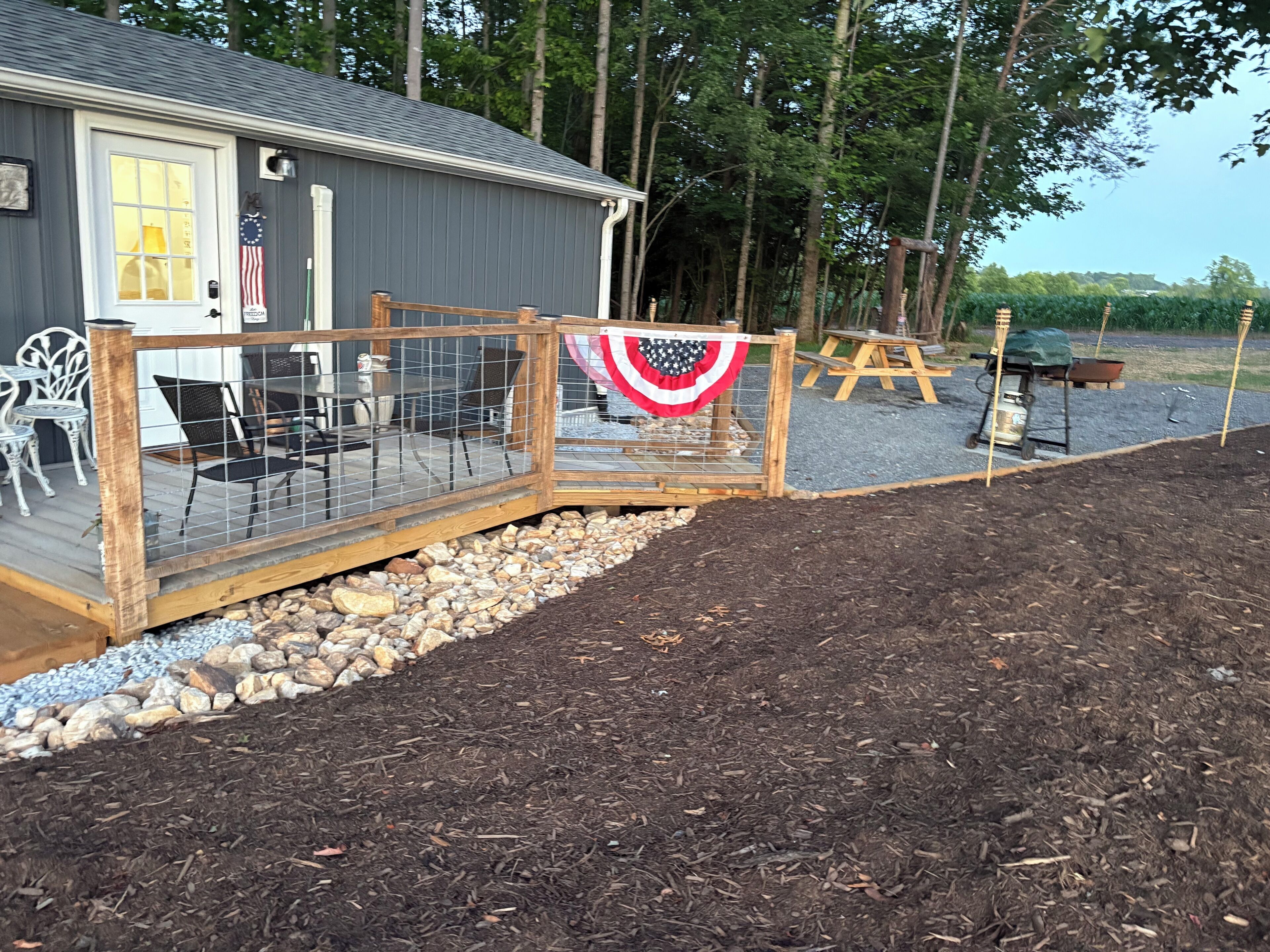 A house with a deck, a flag, and a garden.