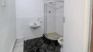 Kylpyhuone, jossa on suihku, pesuallas ja wc.