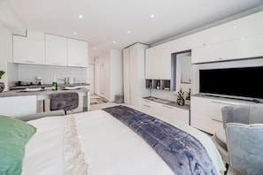 A modern bedroom with a large bed, a desk, and a TV. - Zagreb City Center Vibes Near Main Square (Zagreb)