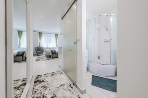 A modern bathroom with a glass-enclosed shower, a bathtub, and a walk-in shower area. - Zagreb City Center Vibes Near Main Square (Zagreb)