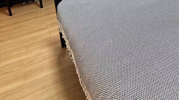 A room with a bed, a piano, a dining table with chairs, and a window with curtains.