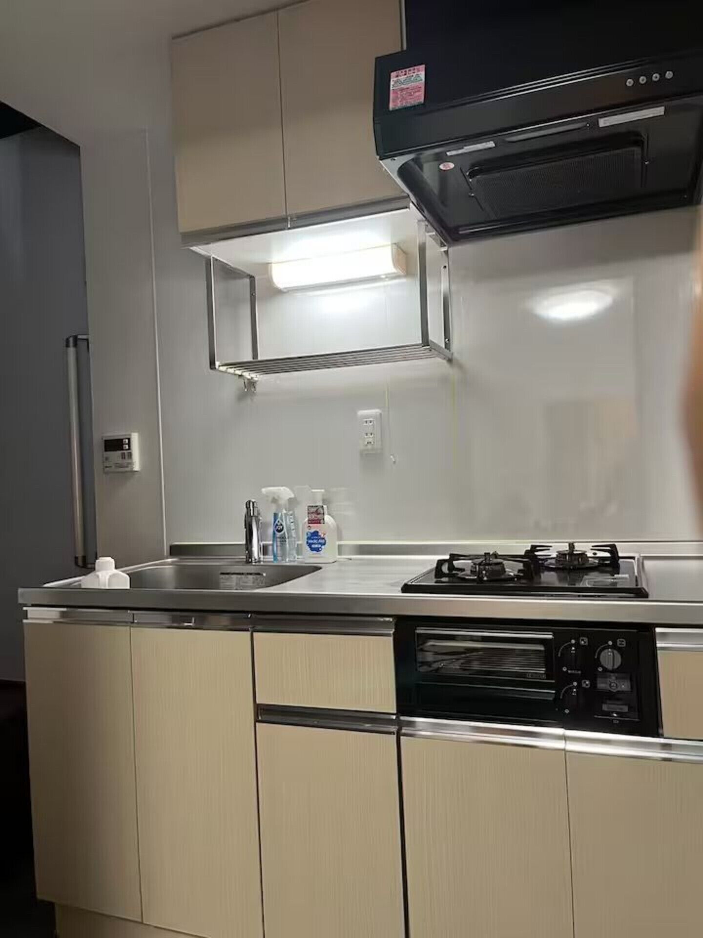 A compact kitchen with a gas stove, a dishwasher, and a stainless steel sink.