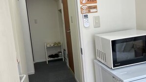 A hallway with a microwave, a clock, and a sign indicating WiFi availability.