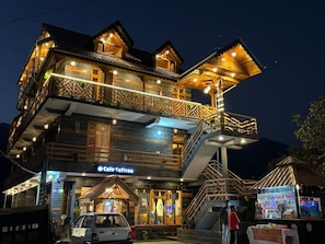 A multi-story building with a cafe named 'Cafe Saffron' on the ground floor, featuring a staircase and a small outdoor seating area.
