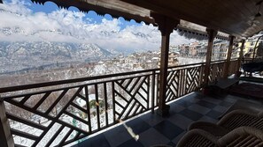 A balcony with a view of a snow-covered mountain range.