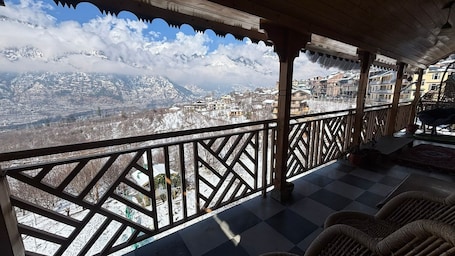A balcony with a view of a snow-covered mountain range.. Cafe Saffron Sips & Stays