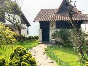 A stone building with a tiled roof, a stone entrance, and a pathway leading to the door. - Premium Two-Bedroom Villa with Mountain Balcony (Sa Pa)