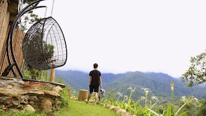 Eine Person geht auf einem Steinweg, im Hintergrund Berge.