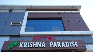 A hotel sign with the name 'KRISHNA PARADISE' and a peacock logo. - Krishna Paradise (Jahazpur)