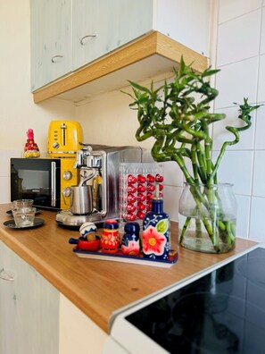 Eine Küche mit Mikrowelle, Toaster, Kaffeemaschine und einer Pflanze auf der Arbeitsplatte.