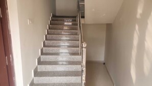 Una scala con ringhiera in metallo e una porta in legno sul lato sinistro.