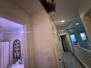 A hallway with a door leading to a bathroom, a staircase, and a view of the outdoors. - Cozy, with unique European settings close to strip (Las Vegas)