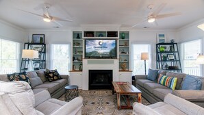 Ein Wohnzimmer mit zwei Sofas, einem Couchtisch, einem Kamin und einem Fernseher.