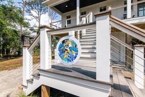 Eine Treppe führt zu einem Gebäude, das ein kreisförmiges Emblem mit einem Drachen und dem Text 'THE SANDLOT' zeigt.