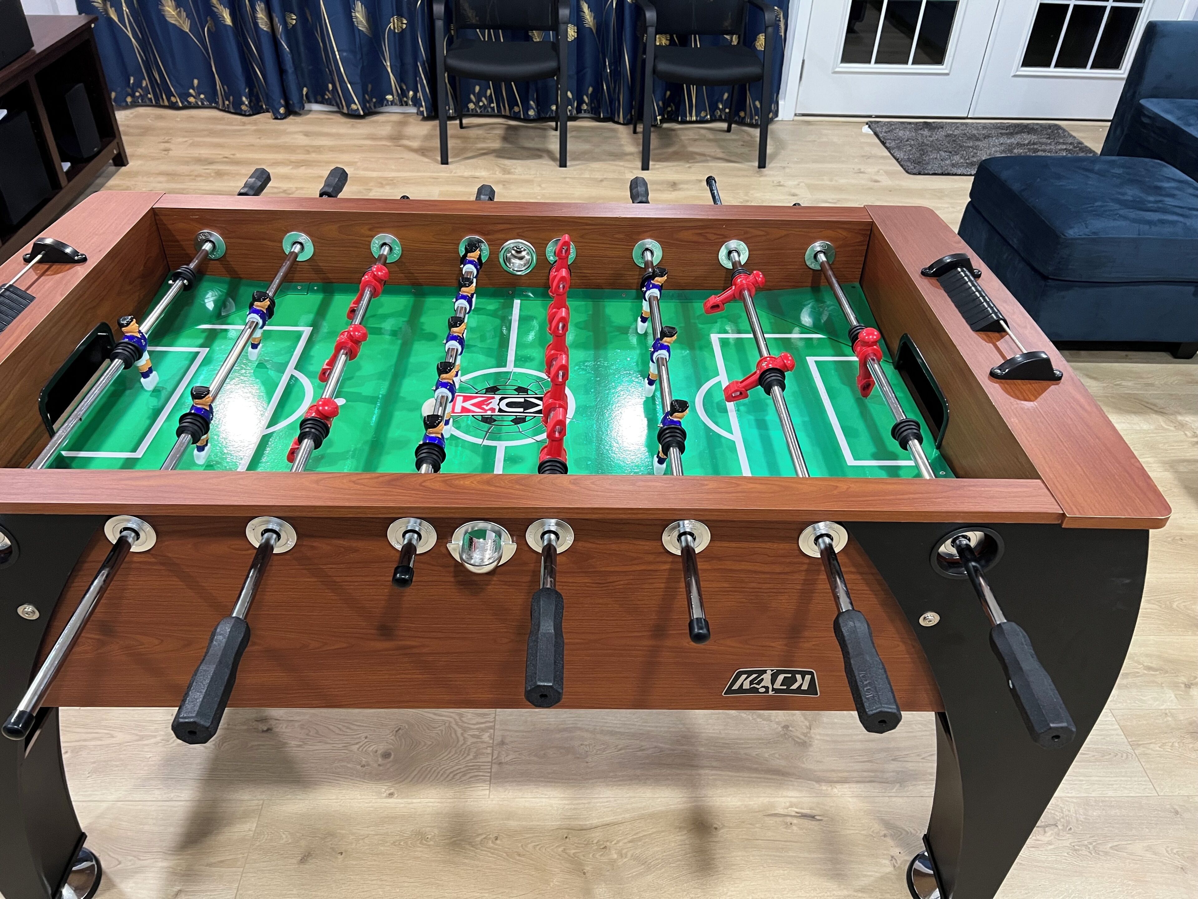 A foosball table with multiple players, a logo, and a wooden frame.