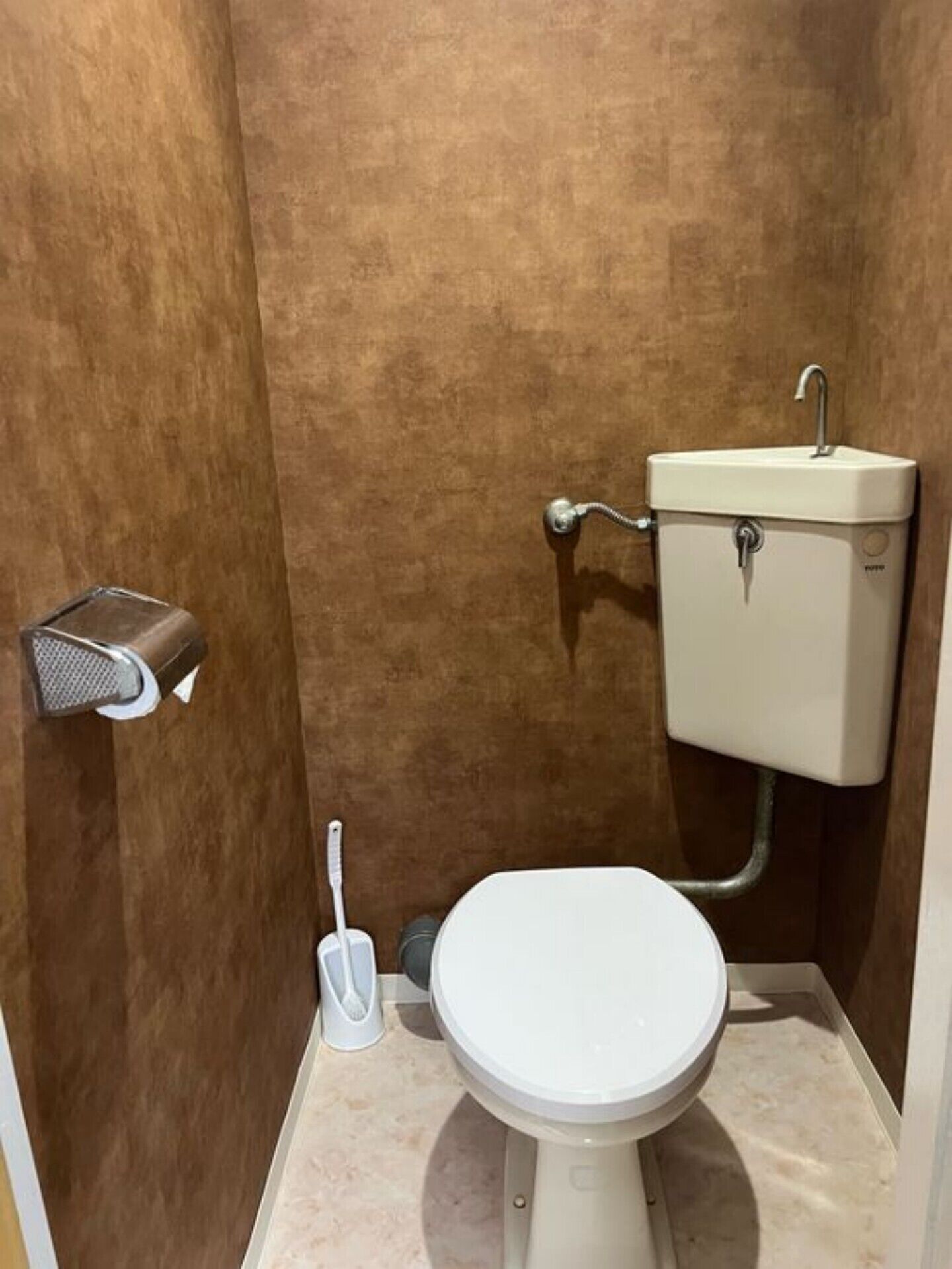 A small bathroom with a toilet, a bidet, and a shower area.