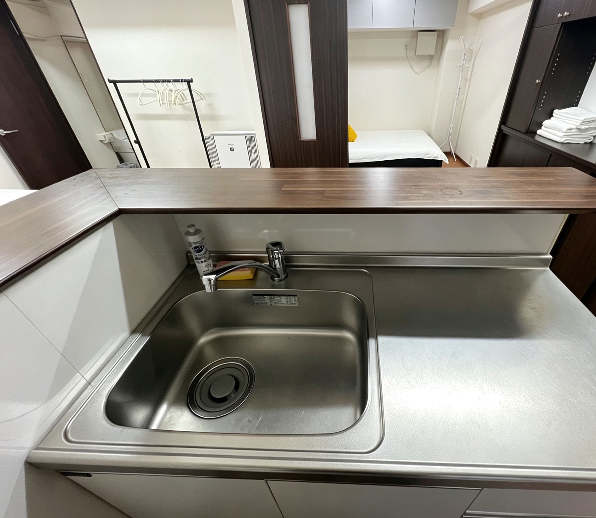 A modern kitchen with a stainless steel sink, a faucet, and a soap dispenser.