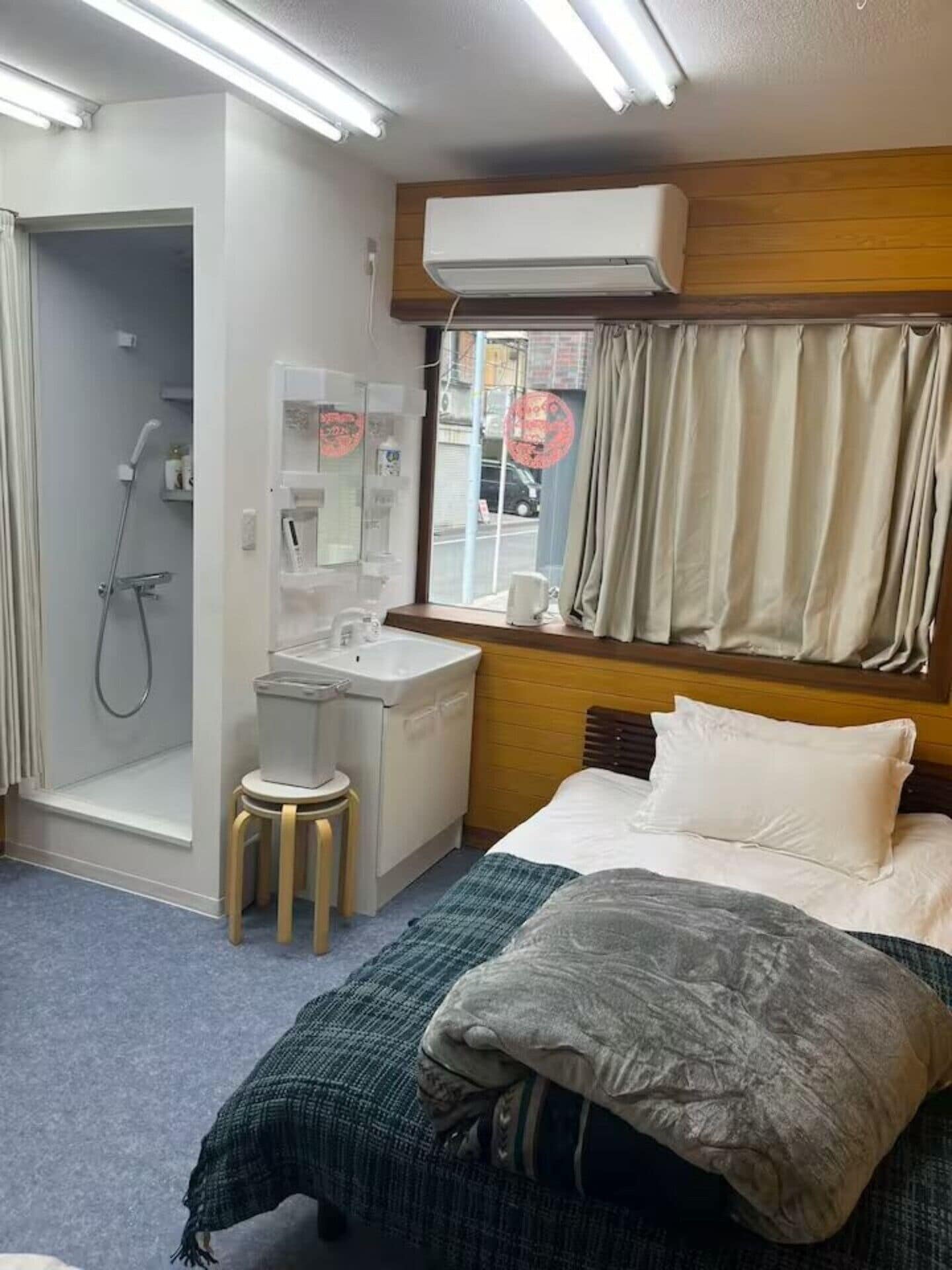 A hotel room with a shower, sink, and bed.