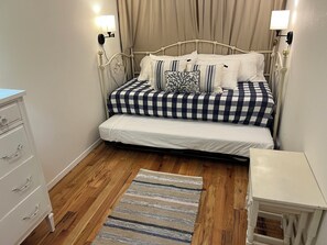 A bedroom with a bed, bedside tables, a dresser, and a rug.