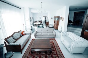A living room with a sofa, armchair, and a coffee table. - Twins'house (Abruzzo)