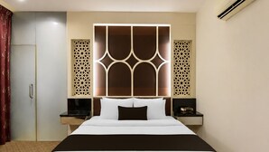 A hotel room with a large bed, a nightstand, a wardrobe, and decorative wall panels. - Palette - Near Amanjaya Mall Formerly El-Zahraa (Sungai Petani)