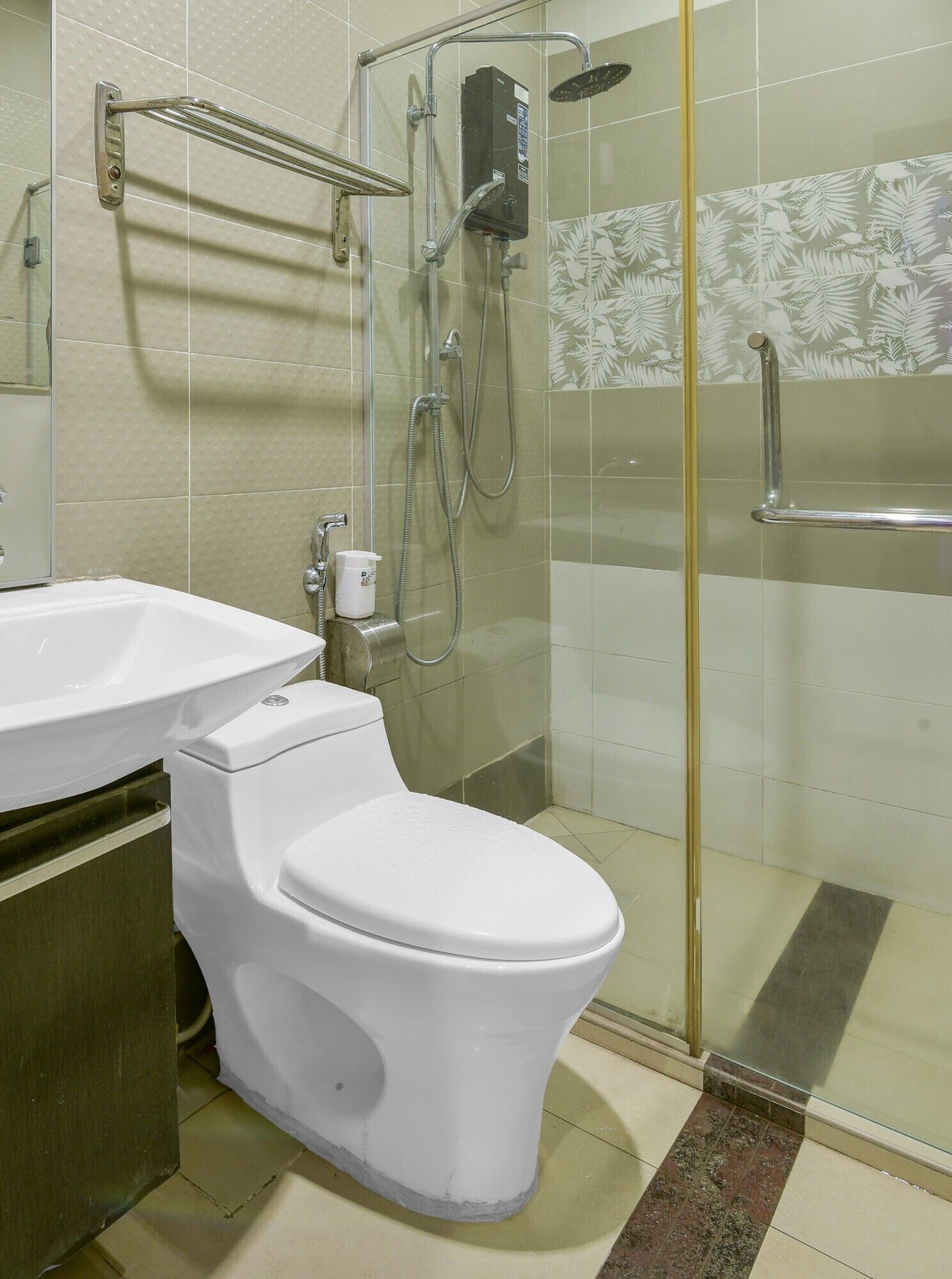 A bathroom with a toilet, sink, shower, and glass door.