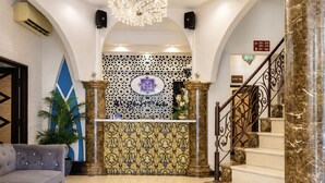 A lobby with a reception desk, a staircase, and a patterned wall. - Palette - Near Amanjaya Mall Formerly El-Zahraa (Sungai Petani)