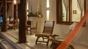 A room with a wooden ceiling, a hammock, and a window with curtains. - Tierra del Mar (Isla Holbox)