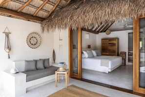 A modern bedroom with a large bed, a sofa, and a small table. - Tierra del Mar (Isla Holbox)