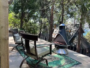 Eine Terrasse mit Grill, Stuhl und Blick auf ein Haus.