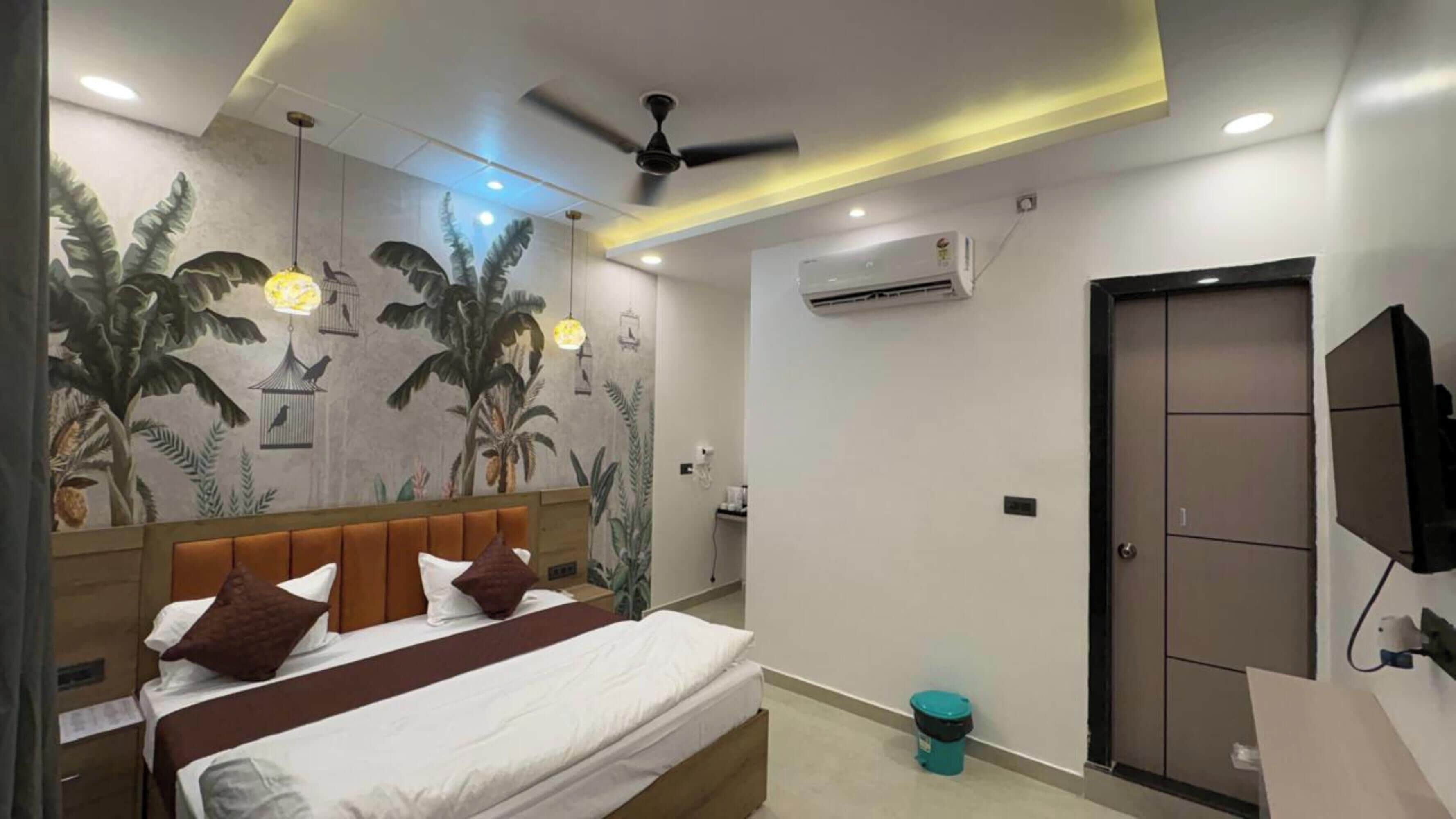 Un dormitorio con cama, ventilador de techo, aire acondicionado, televisor y una puerta.