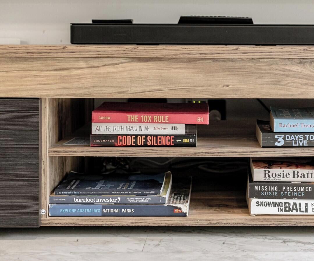 A bookshelf with books and a television.