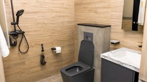 Un baño moderno con inodoro, lavabo y ducha.
