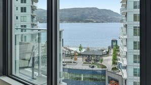 A high-rise hotel with a view of a lake and mountains. - Epic Lake Views | Modern 1BR (Kelowna)