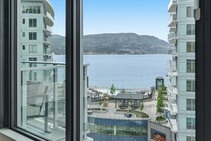 Ein Hochhaus-Hotel mit Blick auf einen See und Berge.
