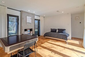 A modern bedroom with a bed, a desk, and a chair. - Charming Houston Getaway (Houston)
