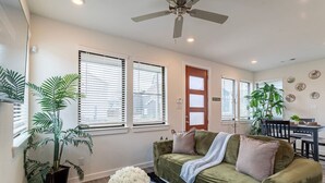 A living room with a sofa, a coffee table with a bowl of flowers, and a ceiling fan. - Cozy 3BR Richmond perfect for relaxation (Richmond)