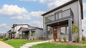 A row of modern two-story houses with balconies, a well-maintained lawn, and a clear sky. - Cozy 3BR Richmond perfect for relaxation (Richmond)
